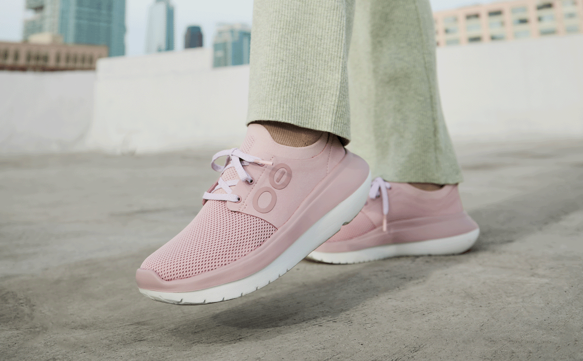 Women's OOmy Stride - Stardust model standing outside with foot lifted | lifestyle