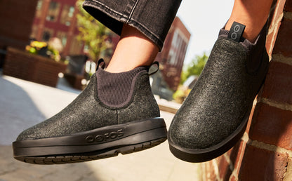Women's OOmega Londoner - Charcoal model sitting on brick wall outside | lifestyle