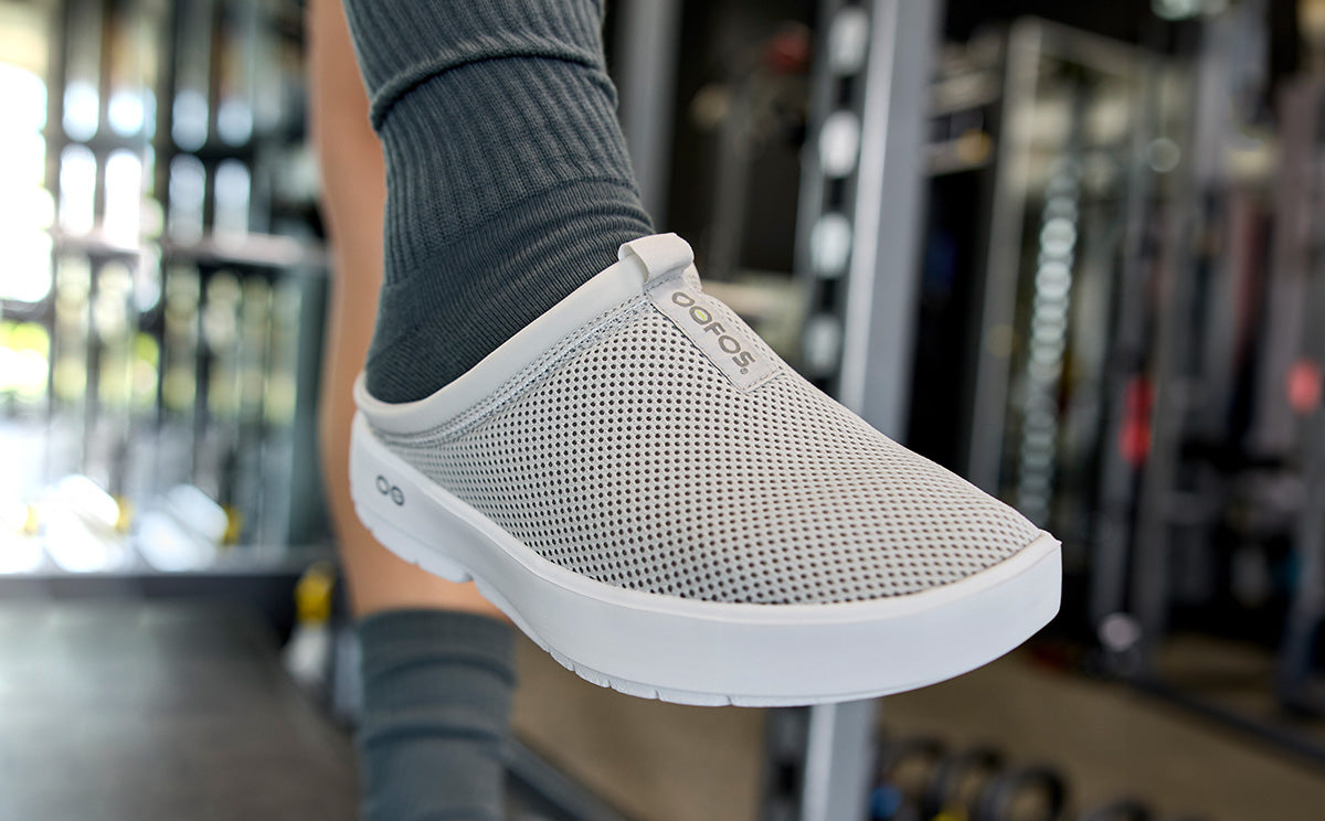 Women's OOcoozie Sport Mule - Gray close up of shoe on model in gym | lifestyle