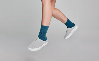 Women's OOcoozie Sport Mule - Gray model hanging in studio with feet dangling | lifestyle