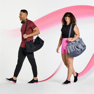 Male and female model in studio carrying duffle bags wearing oomg sport fire fade and oomg sport pink fade. fade treatments in background