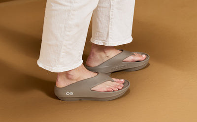 Person wearing driftwood sandals on a brown background | lifestyle