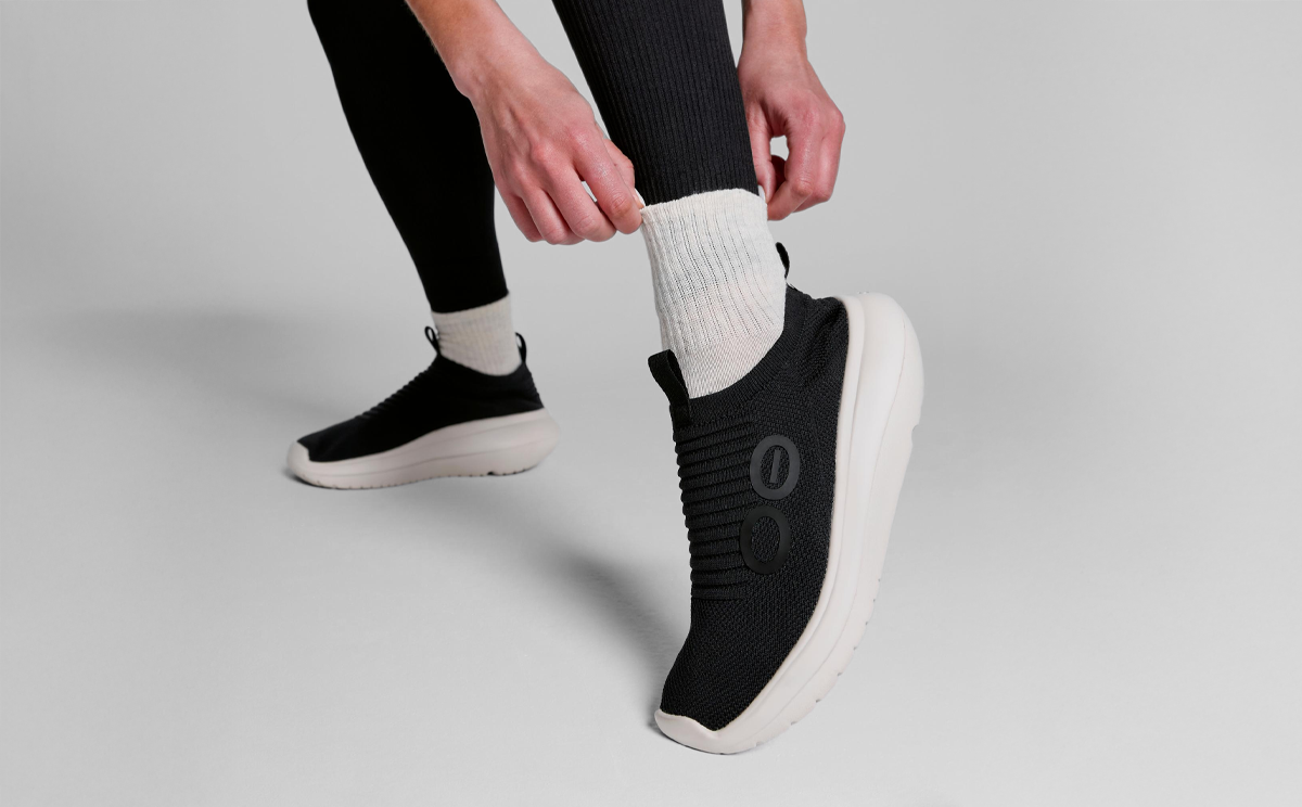 Women's OOmy Zen - Chalk Black model standing adjusting sock in studio | lifestyle