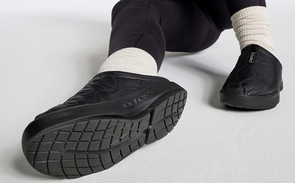 Women's OOcoozie Thermo Mule - Black close up of shoes on model sitting in studio | lifestyle