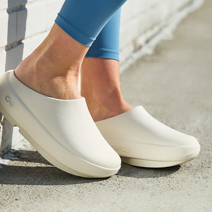 Chalk clogs worn by a person on a concrete surface