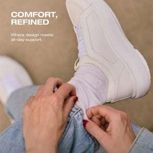 Person putting on a white sneaker with text about comfort and design.