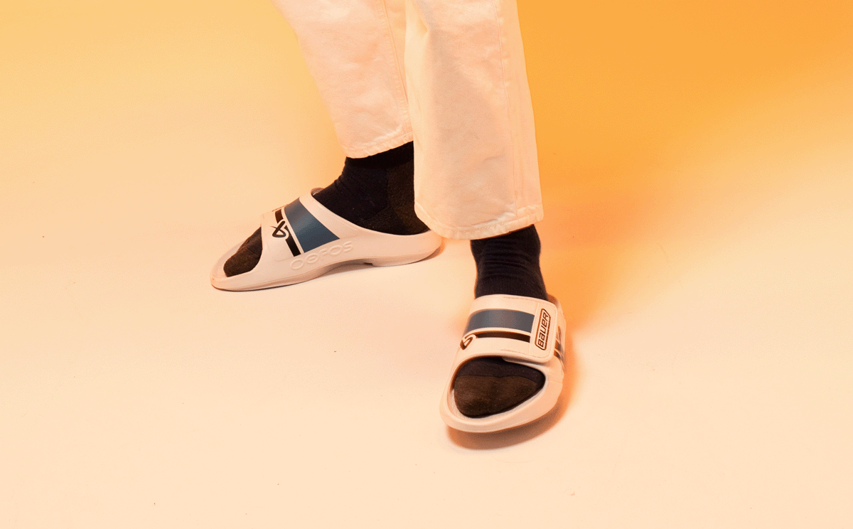 BAUER/OOFOS Men's OOahh Sport Flex Sandal – White model standing in studio | lifestyle